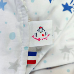 cape carré bain ourson bleu clair imprimé étoiles filantes éponge bambou détail étiquette et ruban bleu blanc rouge