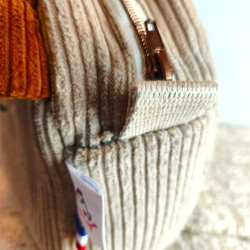 Fermeture à glissière métallique robuste style laiton vieilli avec patte de maintien en tissu.